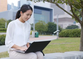 Woman working on laptop outdoors in a park