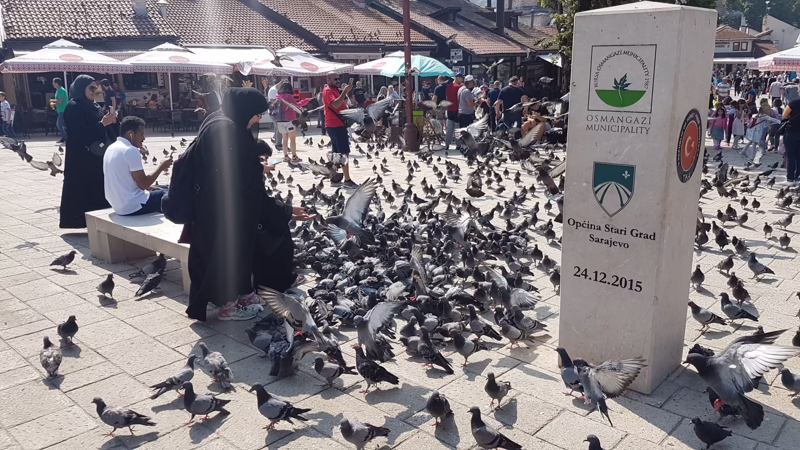 Lady feeding a flock of pigeons in Pigeon Square, Baščaršija, Sarajevo.
