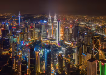 Skyline of Kuala Lumpur, Malaysia at night. Lit up urban landscape with the Petronas Towers and Menara KL (KL Tower) in view.