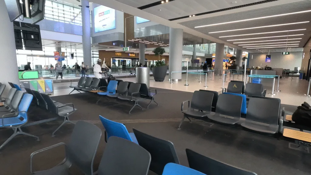 Seats at Istanbul Airport, passenger conveyor belt and wide windows with a lot of natural light.