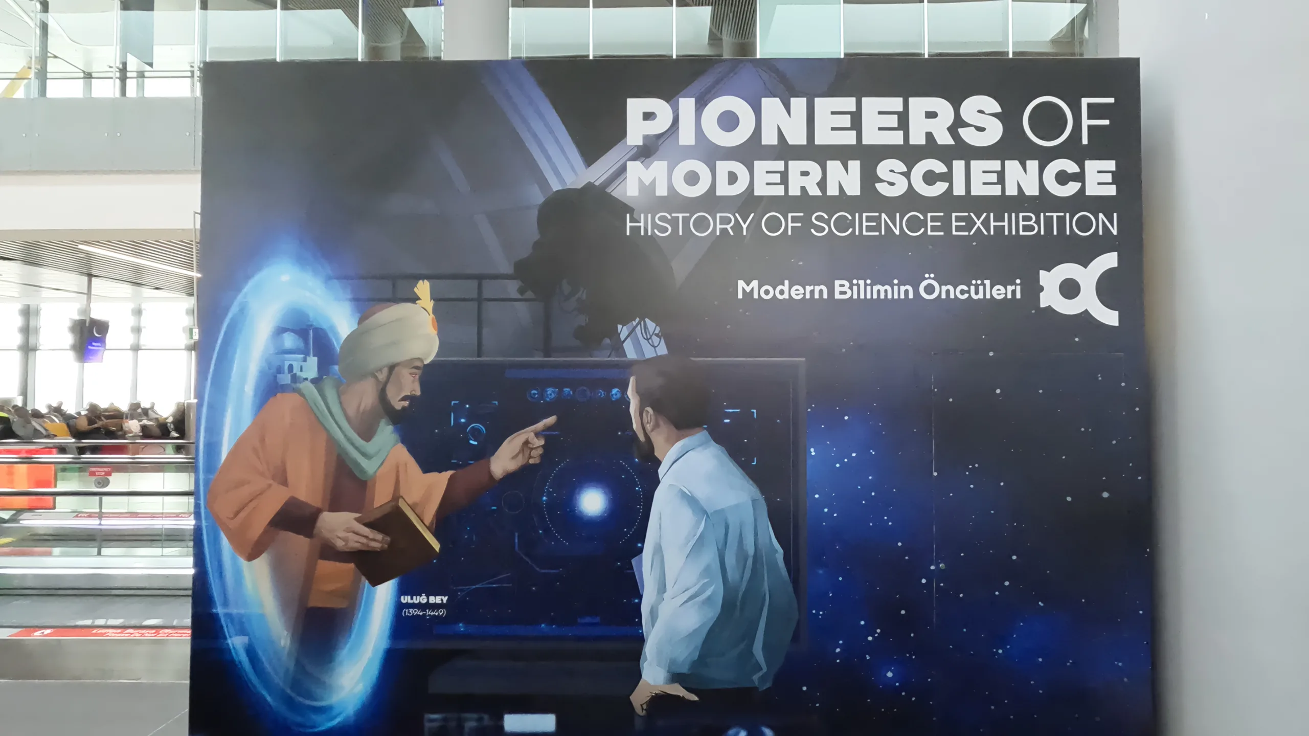 Poster at Istanbul Airport of 15th century mathematician Ulug Bey, emerging from a time portal and teaching a modern individual, Pioneers of Modern Science exhibition.