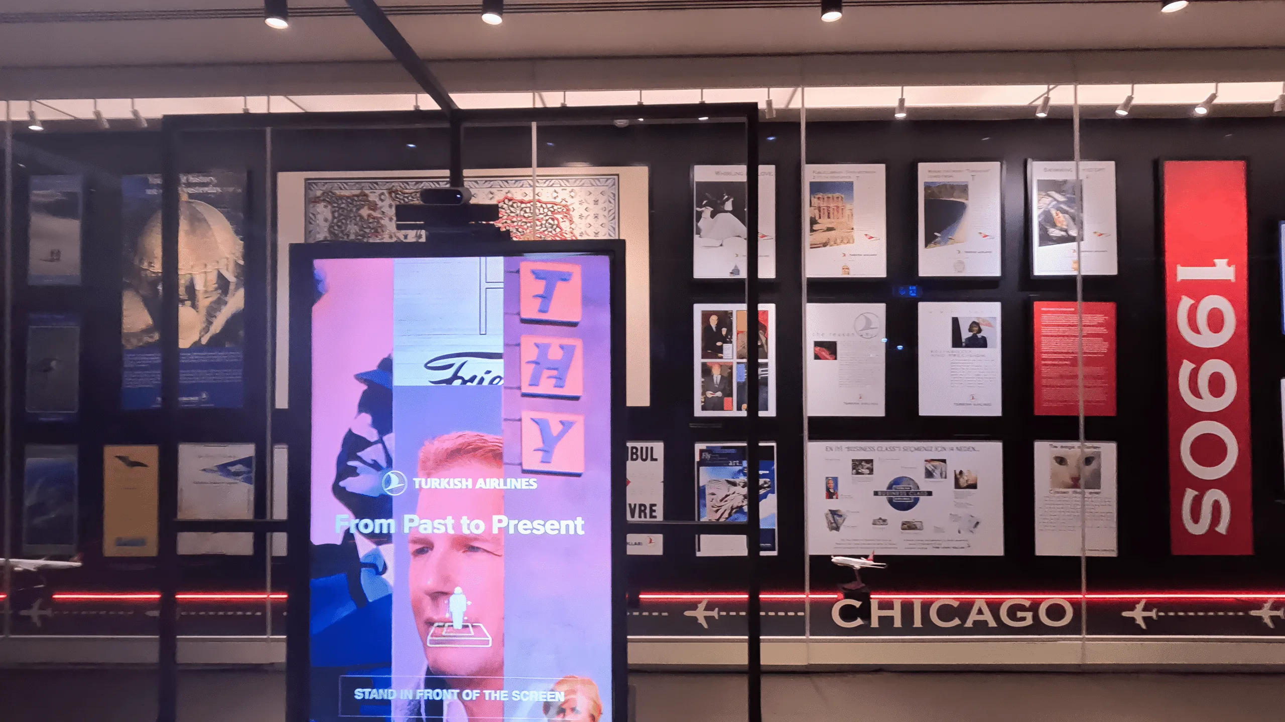 Digital screen and displays of Turkish Airlines marketing material from the 1990s at the Turkish Airlines Business Lounge, Istanbul Airport.