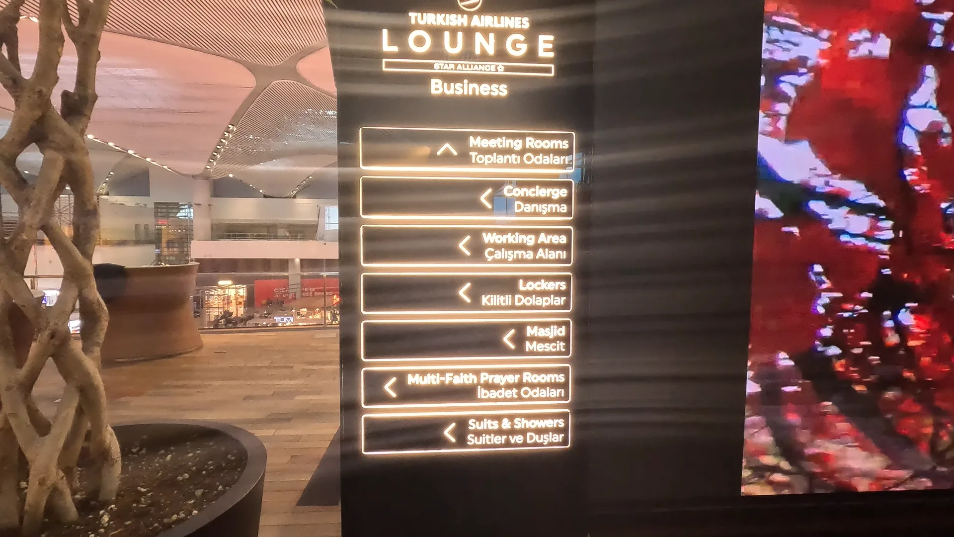 Lit up sign at Turkish Airlines Business Lounge at Istanbul Airport, listing various amenities including Meeting Rooms, Masjid, Showers and Working Area.