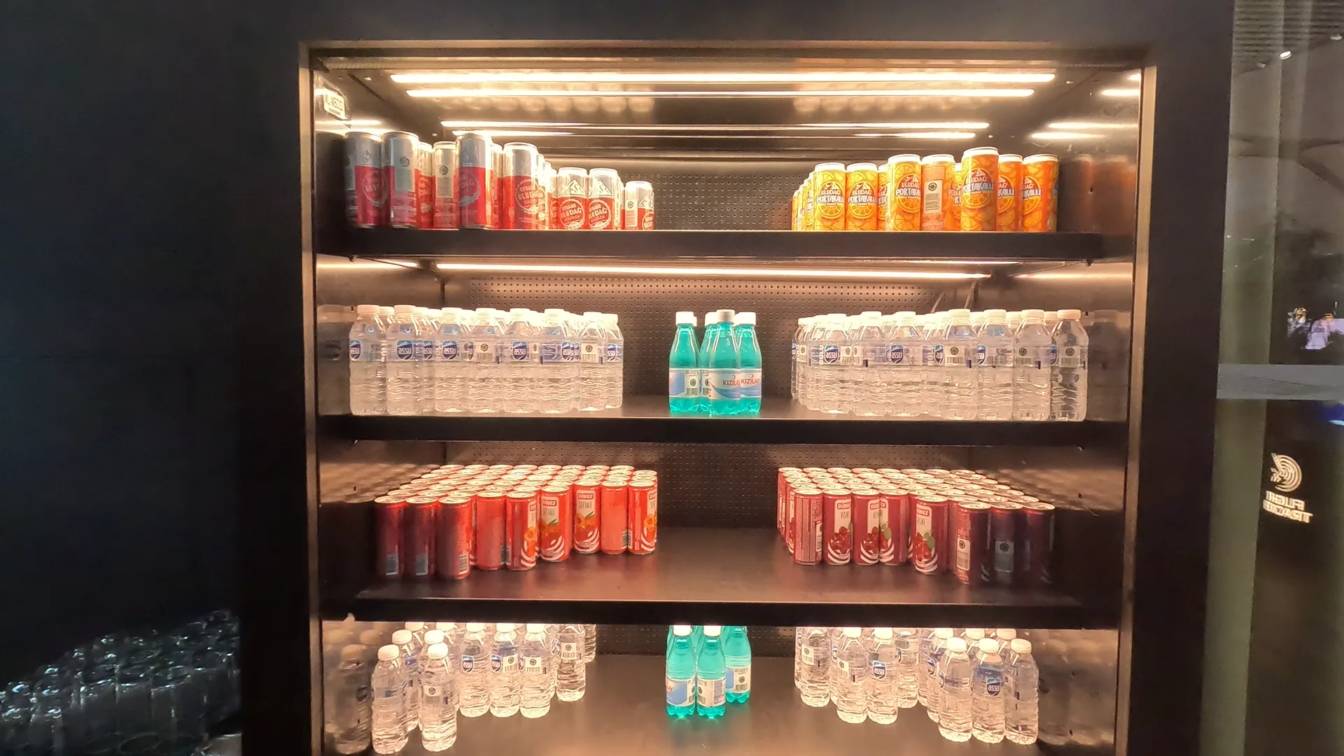 Fridge with bottles of still and sparkling water, and carbonated drinks cans of various flavours, at Turkish Airlines Business Lounge, Istanbul Airport.