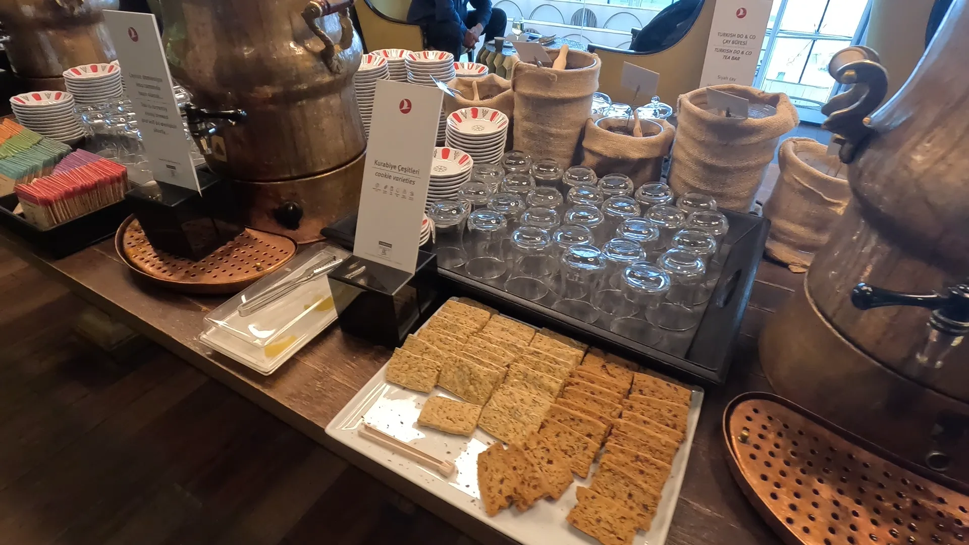 Biscuits, glasses, tea leaves and hot water dispensers on a table at the Turkish Airlines Business Lounge, Istanbul Airport.